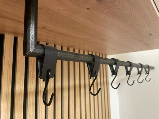Metallstange mit mehreren Garderobenhaken und geschmiedeter Oberfläche