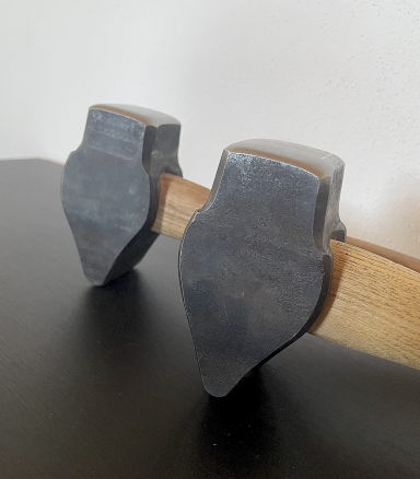 Zwei handgeschmiedete Hämmer mit Holzgriff auf einer dunklen Oberfläche.