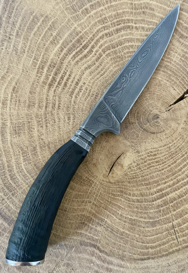 Jagdnicker mit Gamskrucke und Damaststahl-Klinge auf Holzuntergrund.