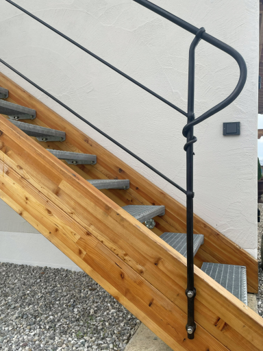 Holztreppe mit geschmiedetem Geländer