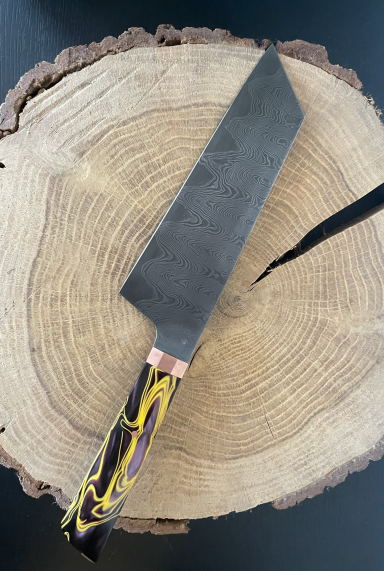 Küchenmesser mit einzigartigem Griff, platziert auf einer Holzscheibe.