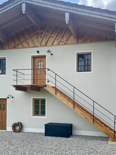 Hauseingang mit Holztreppe und geschmiedetem Geländer