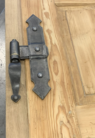 Schlichter Türbeschlag aus schwarzem Metall an einer Tür.